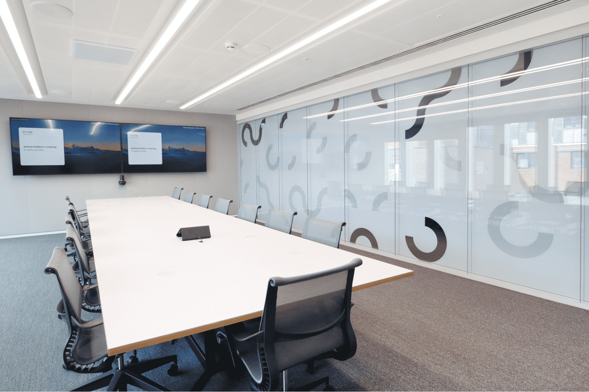 Coworking space design with a large conference room table and privacy glass