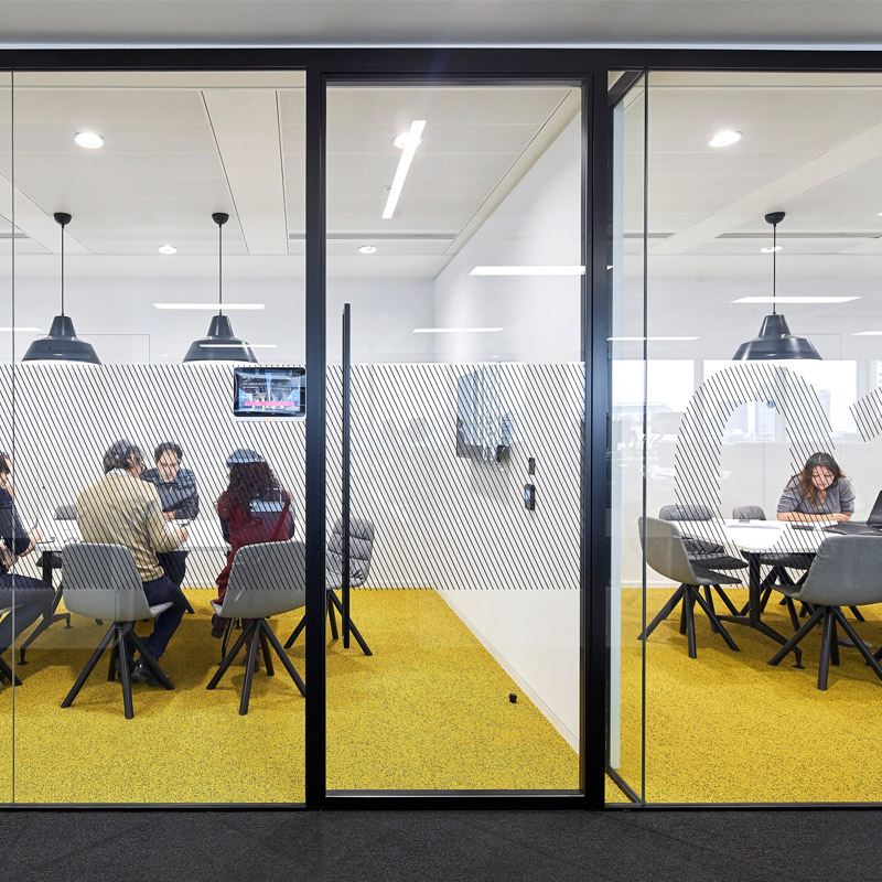an office space with yellow floor that lacks natural light