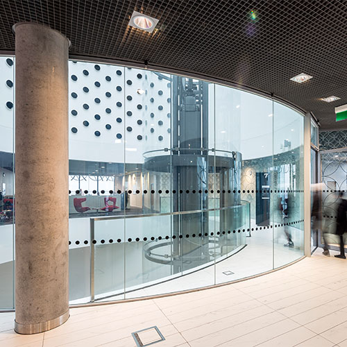 a corporate office interior design with a curved glass partition wall
