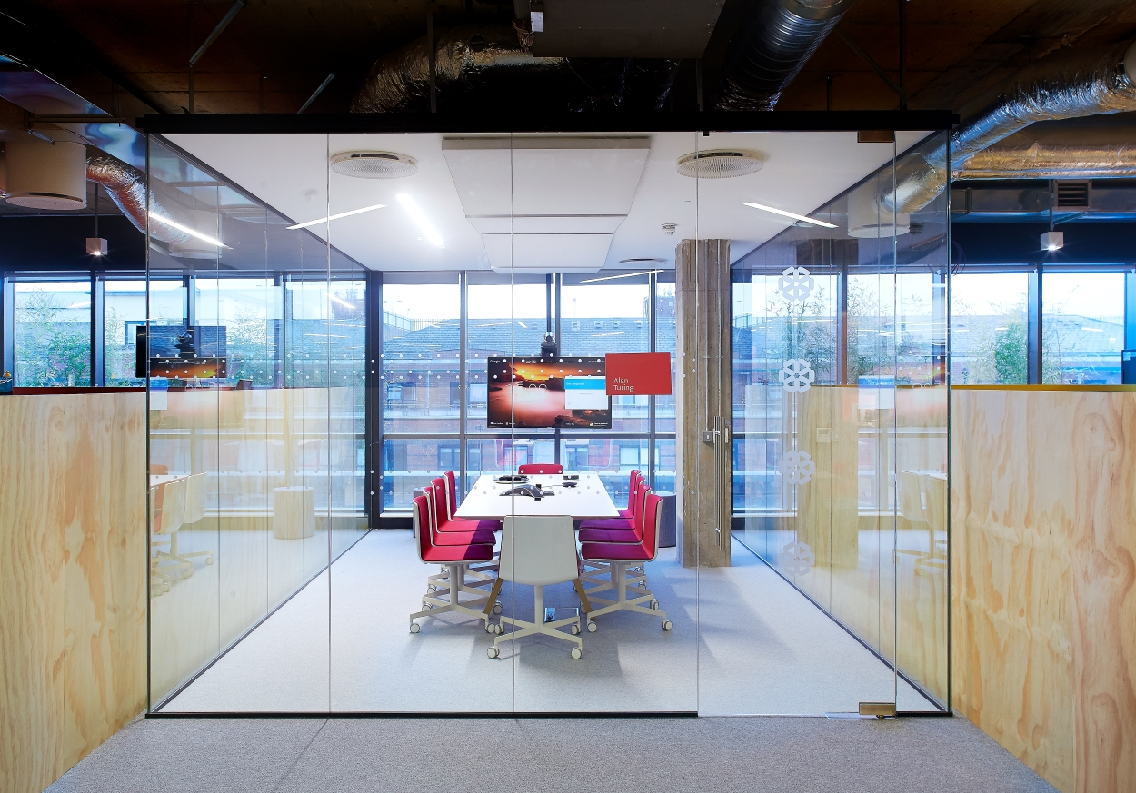 an open office design that has a conference room built for privacy